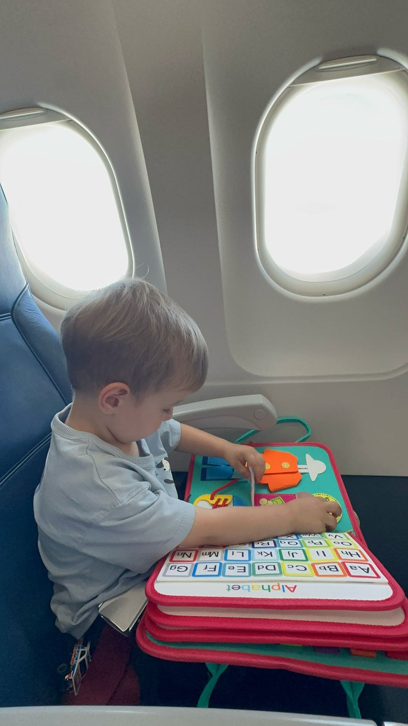 Niño jugando con KinderBoard durante un viaje en avión